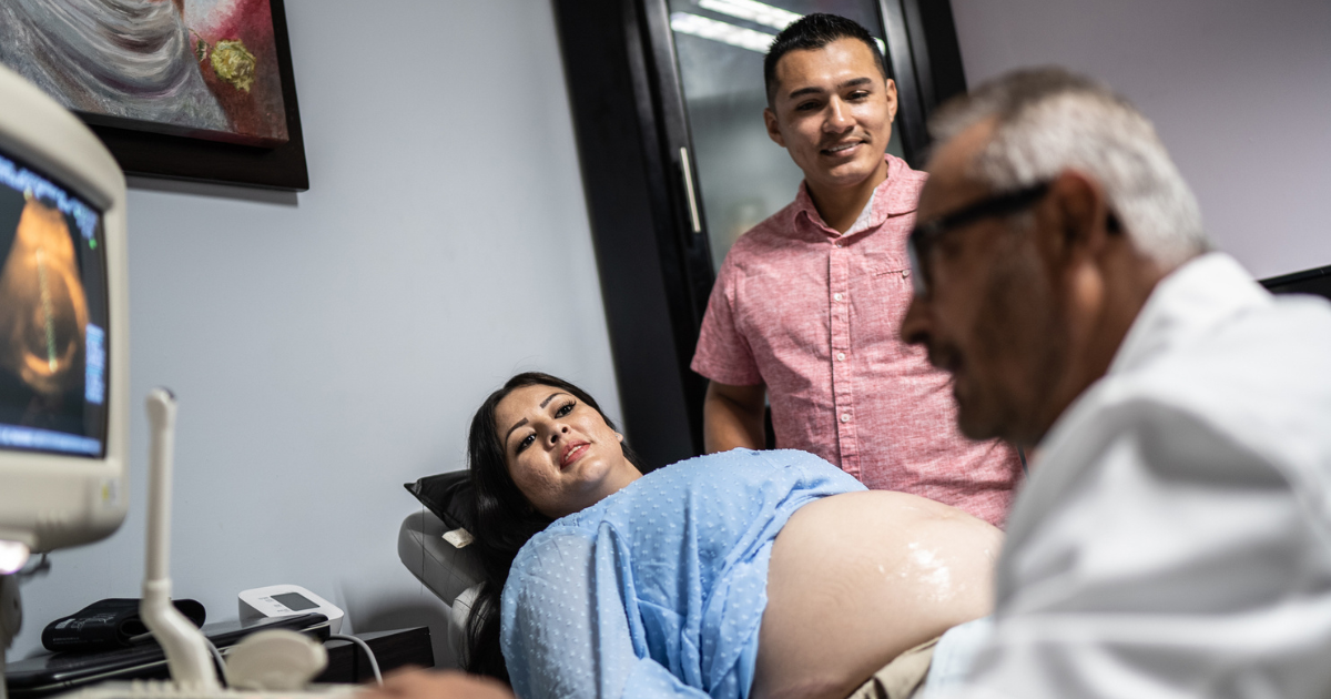 Pregnant woman with husband, getting ultrasound