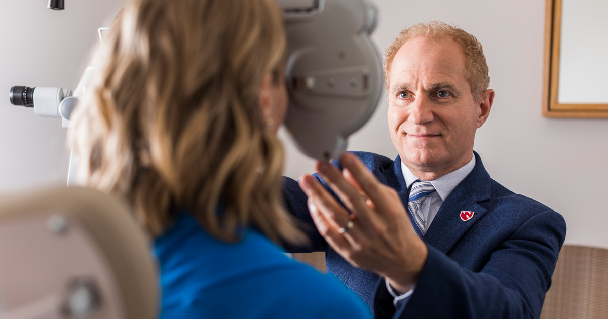 Ronald Krueger, MD, ophthalmologist, evaluating a woman for LASIK surgery