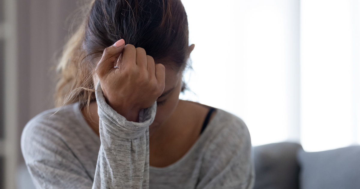 Woman holding her head in her hand