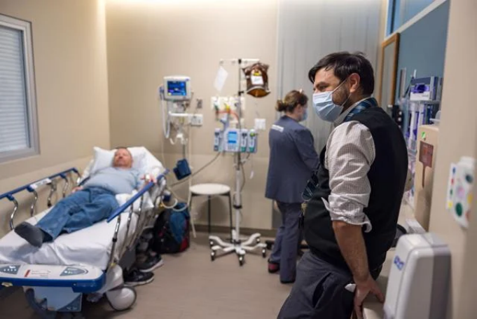 Chad Stevens, left, of Newdale, Idaho, speaks with hematologist Dr. Alex Nester