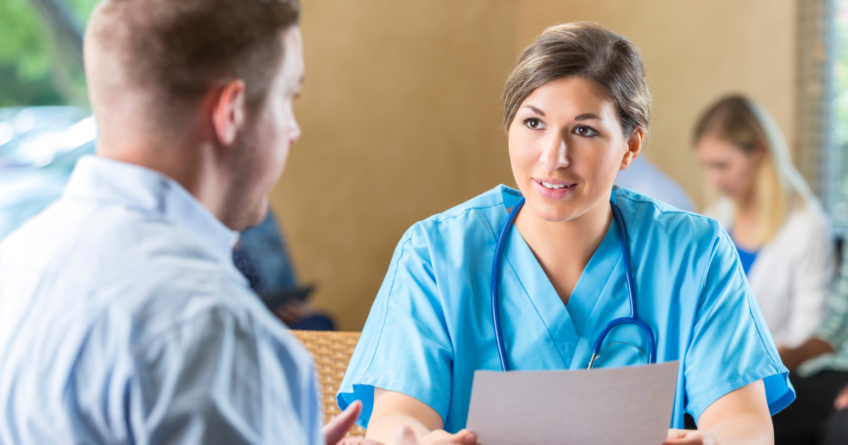 Woman in scrubs talking to man