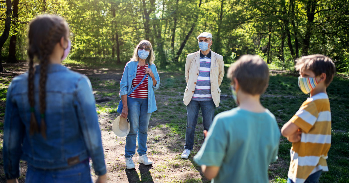 Group of people standing outside wearing masks