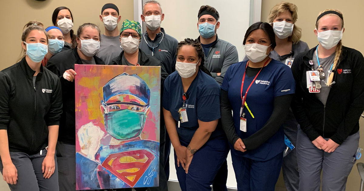 Emergency department poses with Dany Reye's painting