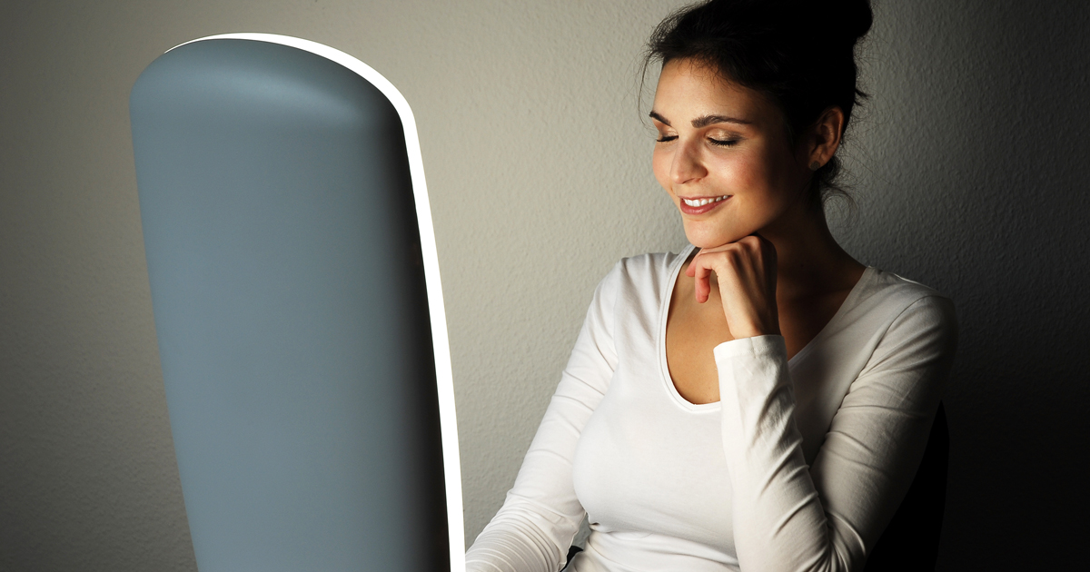 Woman sitting in front of a light