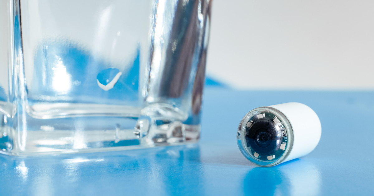 Video capsule sitting next to a glass of water