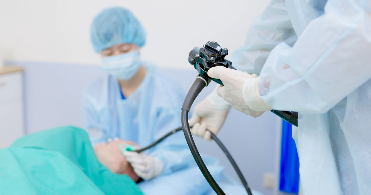 Doctor inserting endoscope into patient's mouth