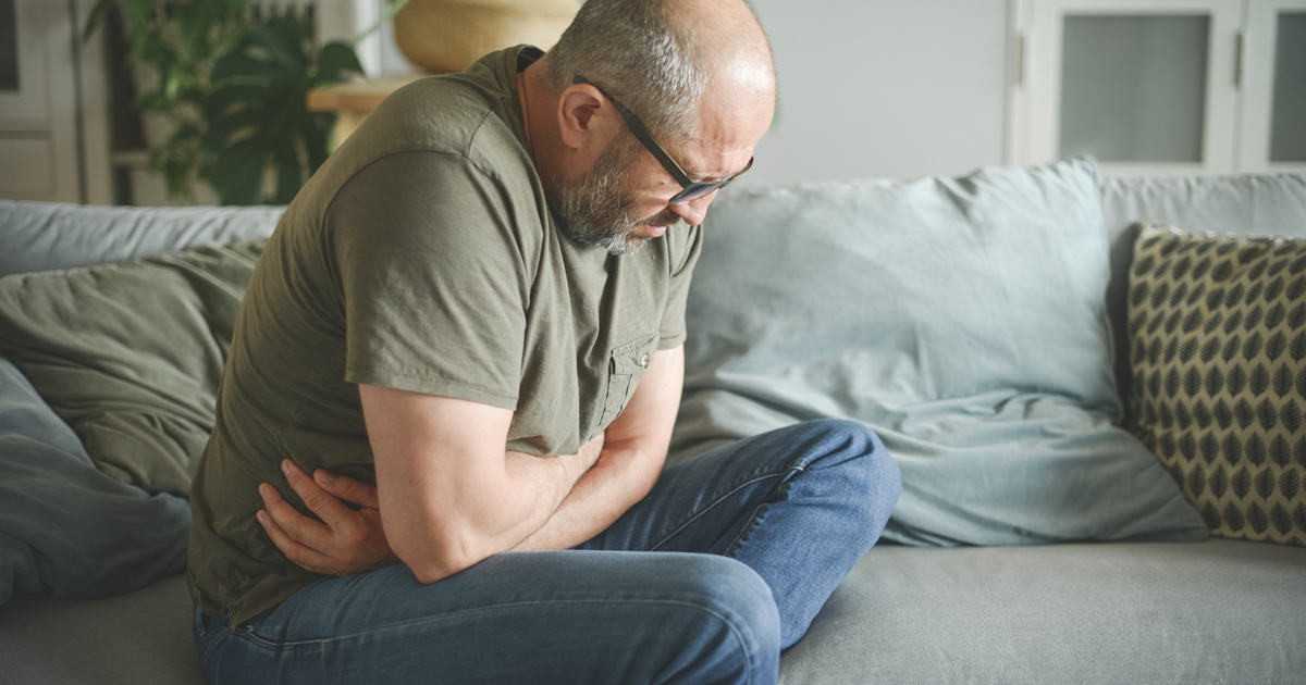 Man in pain holding stomach