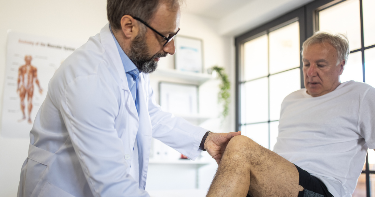 Doctor examining man's leg