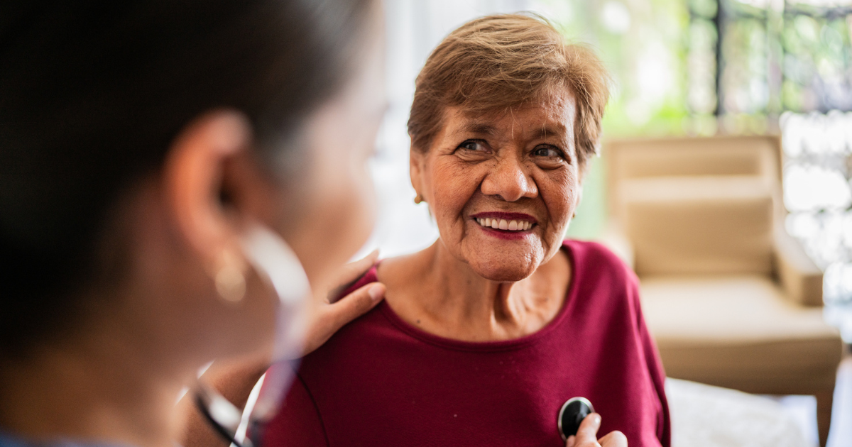 Provider listening to woman's heartbeat