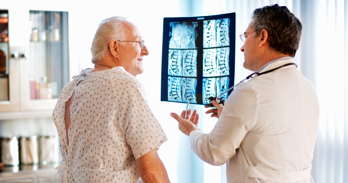 Older man looking at spine x-rays with his doctor