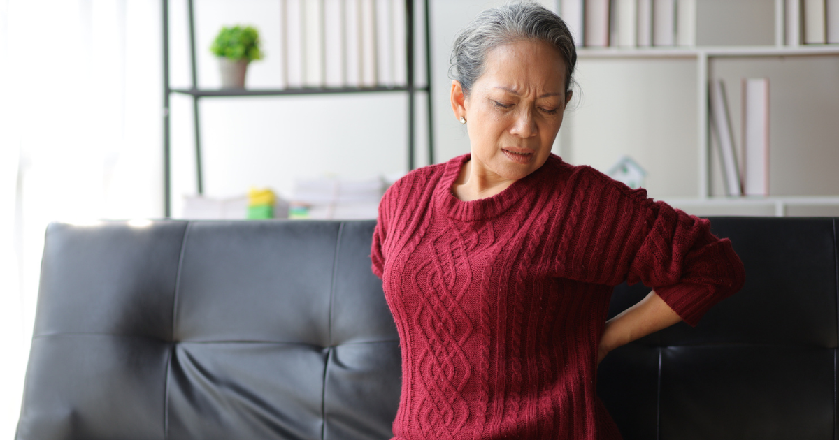 Woman holding her back in pain