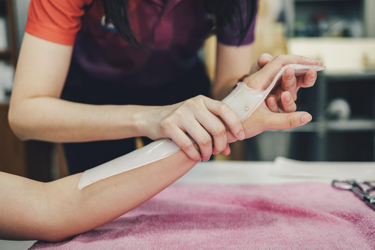 Therapist adjusting patient's hand