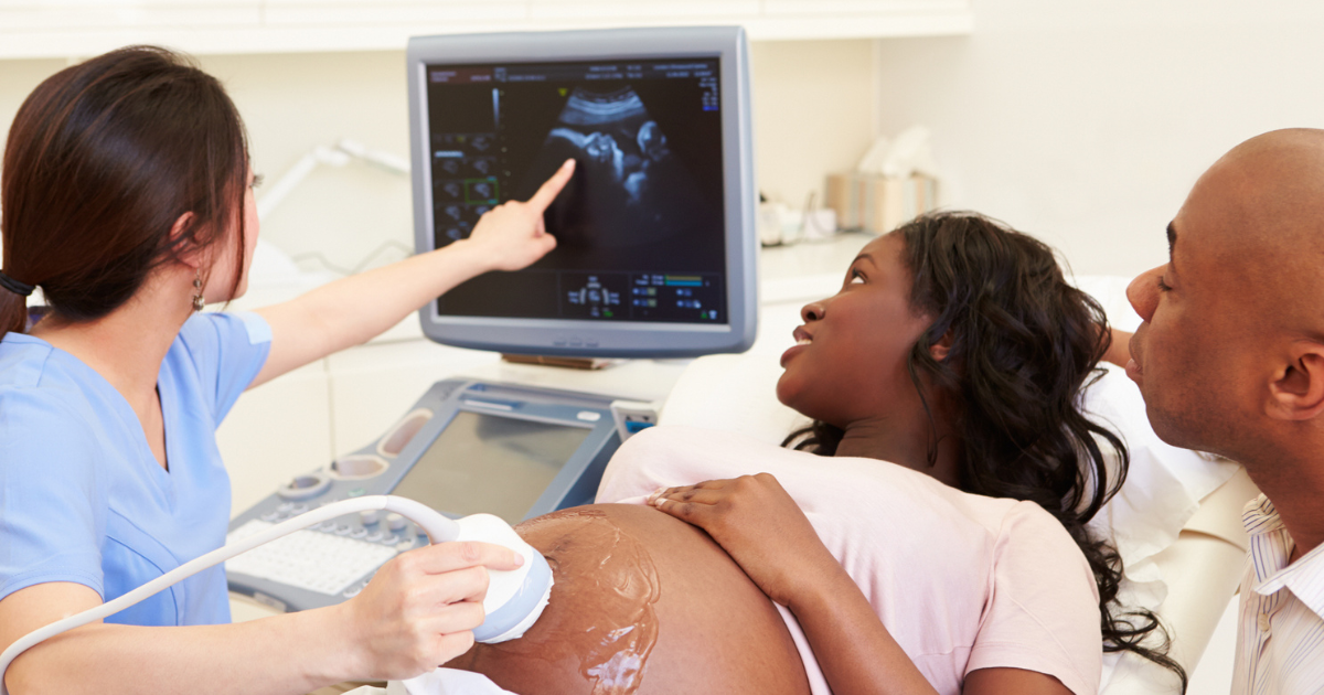 Ultrasound technician performing an ultrasound on a pregnant woman