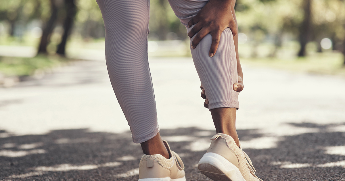 Woman holding cramping leg