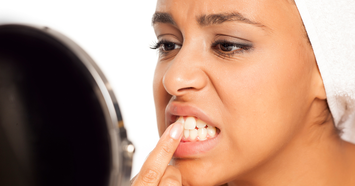 Woman looking at her teeth in a mirror