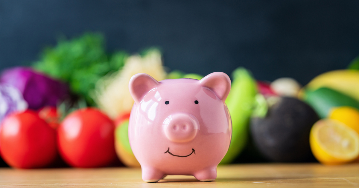Piggy bank in front of fruits and vegetables