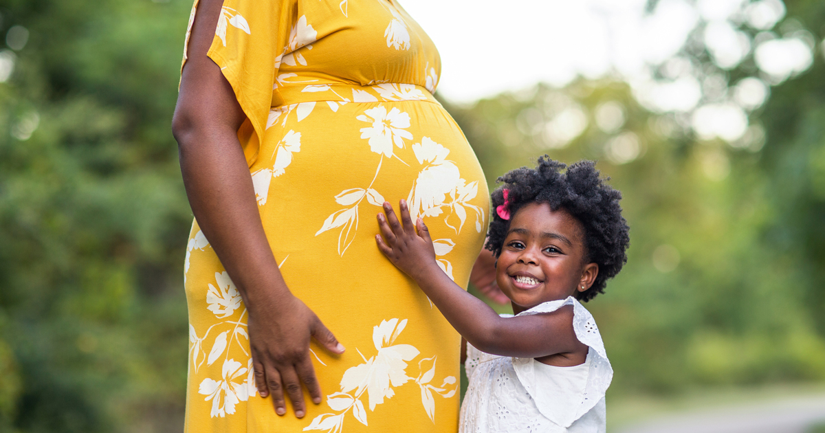 picture of a pregnant woman and her young daughter