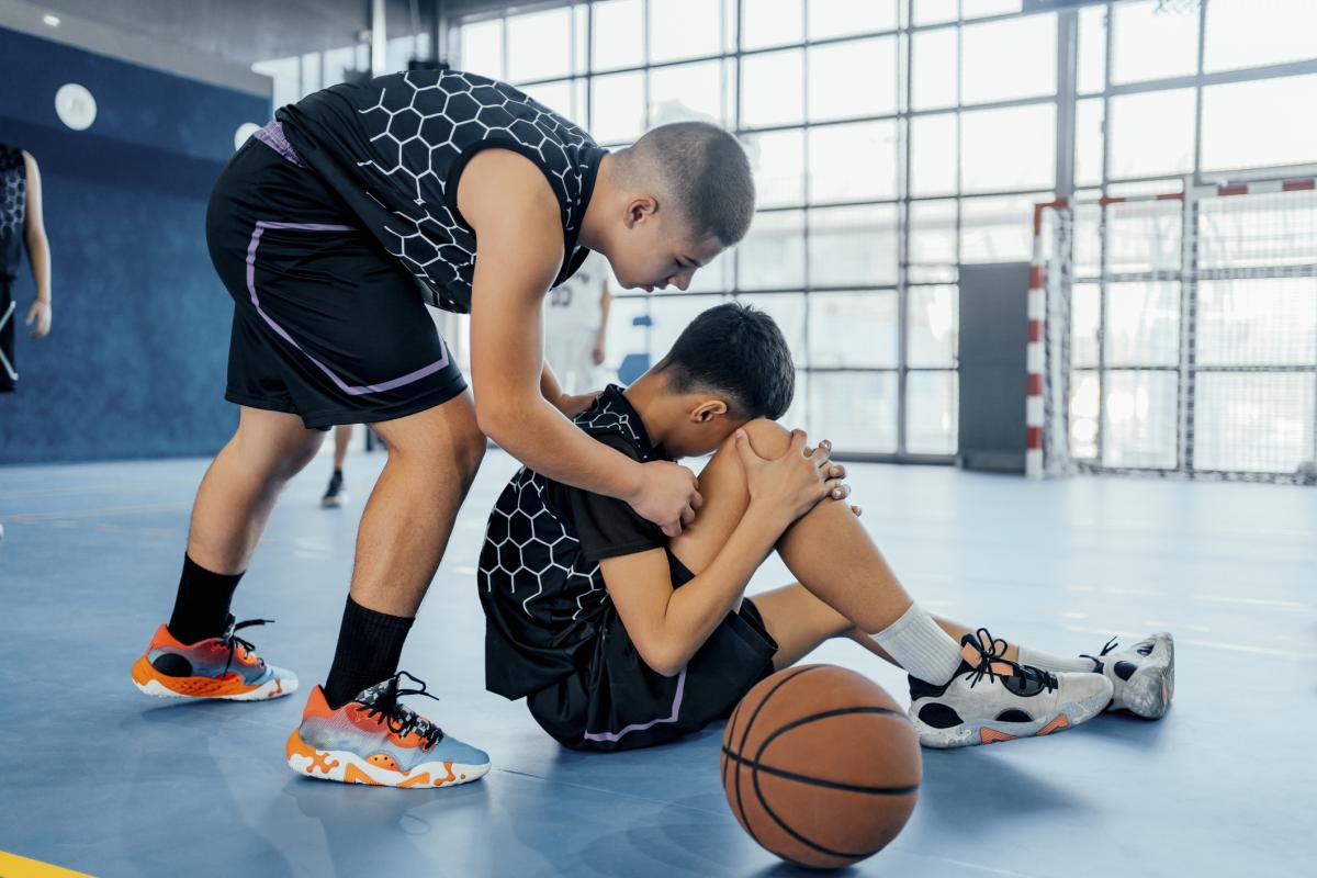 Basketball player sitting on court