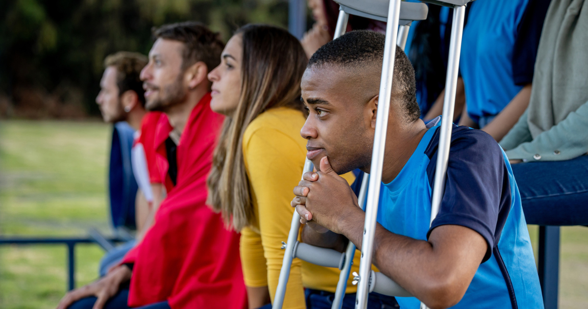 Injured soccer player sitting on the sidelines