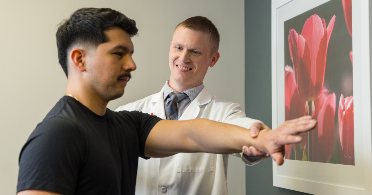 Sports medicine physician evaluating patient's arm