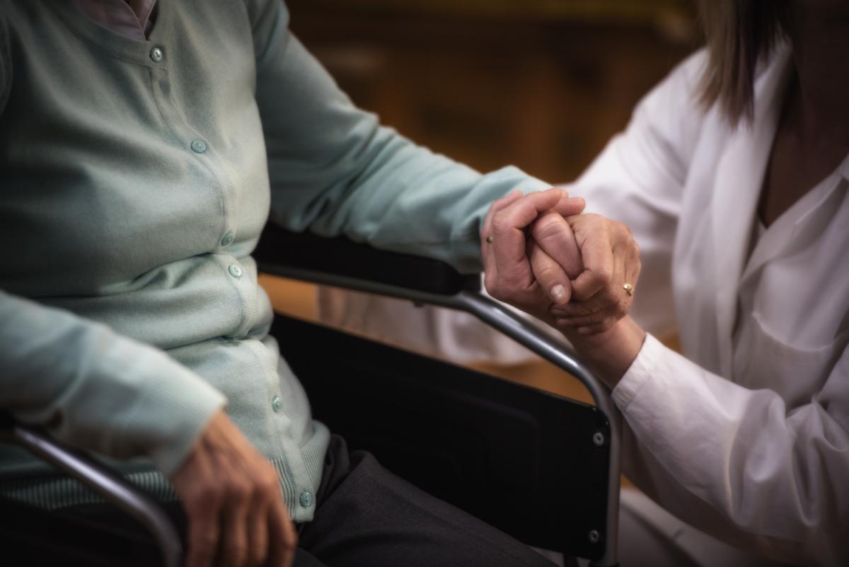 Close up of doctor holding woman's hand