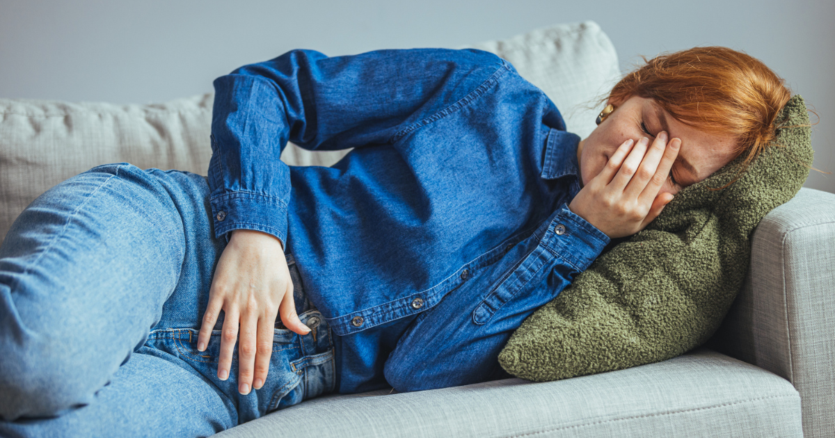 Woman laying on couch with pelvic pain