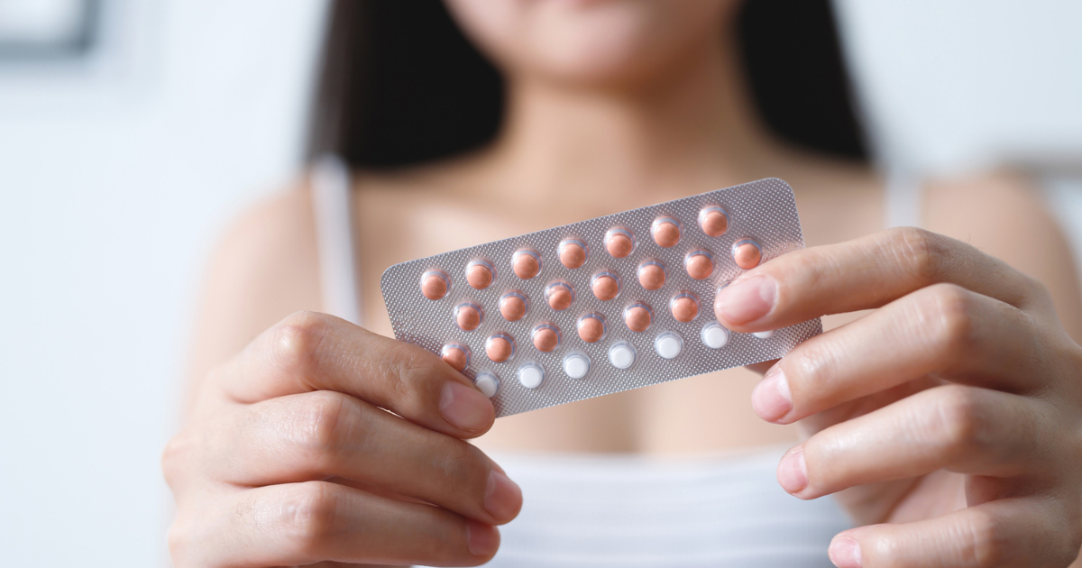 Woman holding birth control pills