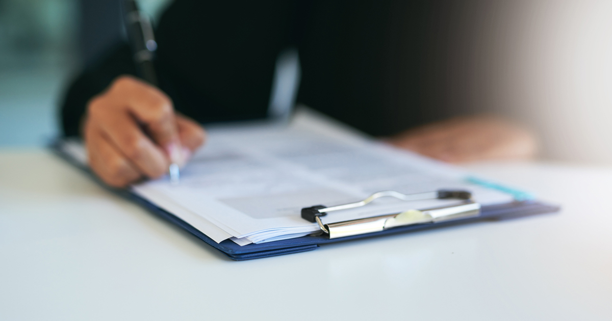 Close up of person signing forms