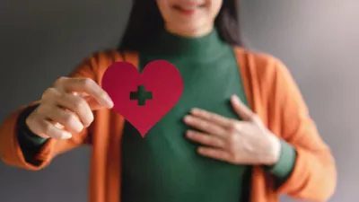 picture of a woman holding a paper heart