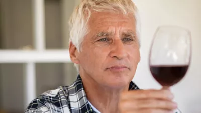 picture of a man looking at a glass of wine