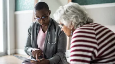 Picture of a doctor speaking to a woman while holding a clipboard