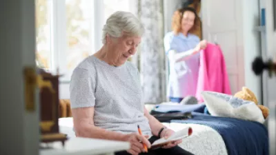 Elderly woman sitting on her bed