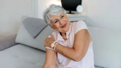 Older woman grabbing her shoulder in pain