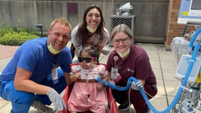 Doerneman, Lexi Albertsen, child life specialist, and Stehlik, pose for a picture with Genesis during a walk.