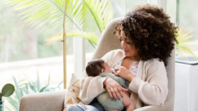 Woman sitting in a rocking chair breastfeeding her baby