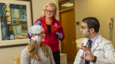 Doctor explaining procedure to patient with a medical cap