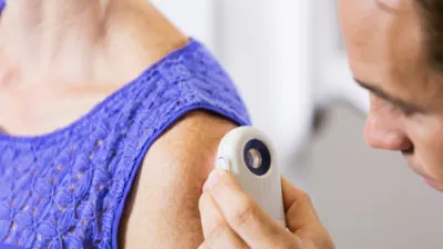 Dermatologist assessing woman's arm