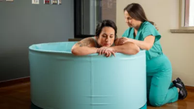 Pregnant woman in water birth tub with NM provider