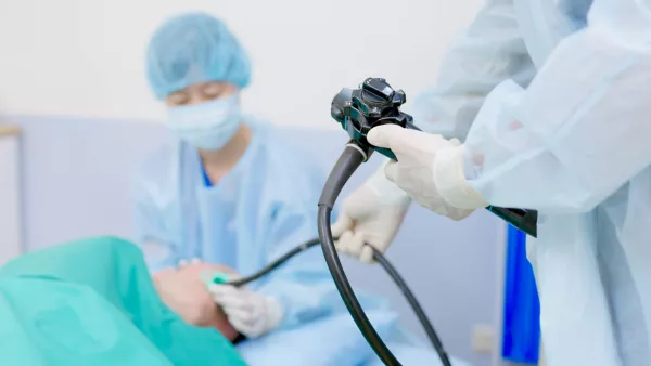 Doctor inserting endoscope into patient's mouth