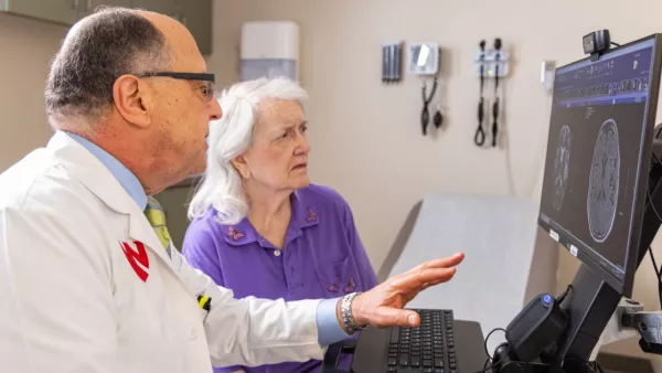 Dr. Fayad looks at brain scans with older female patient