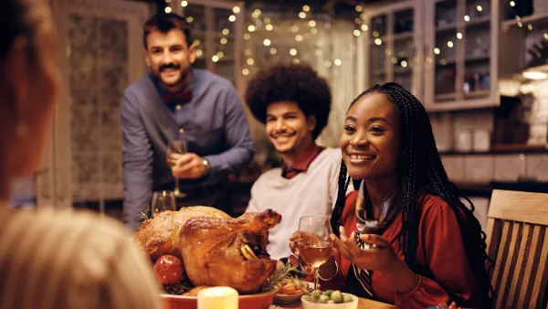 Family sitting around a table eating turkey