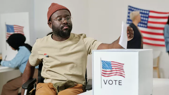 Man in a wheelchair casting a ballot