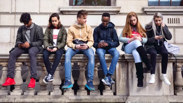 Group of teens holding cellphones