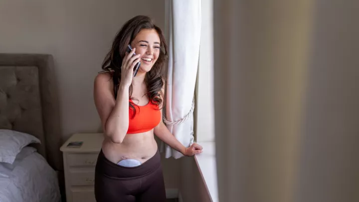 Young woman with ostomy bag talking on cell phone