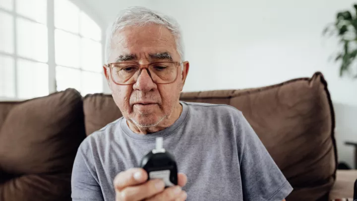 Man looking at glucose meter