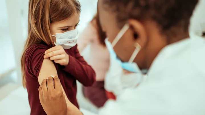 picture of a child getting their COVID-19 vaccine