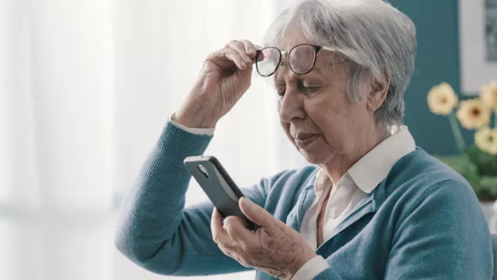 Older woman squinting at her phone