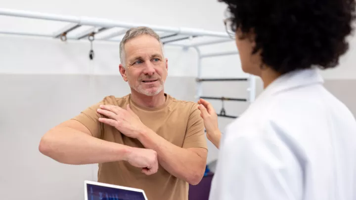 Provider evaluating man with shoulder pain