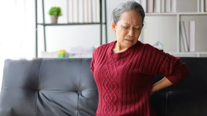 Woman holding her back in pain