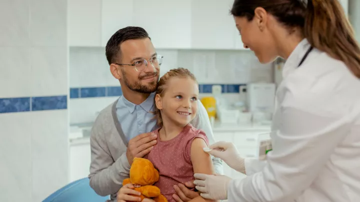 Father and young daughter getting vaccine